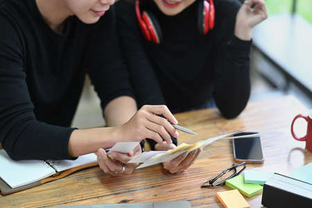 Cropped two creative colleagues working together in office.の写真素材