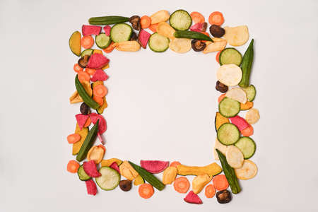 Colorful mix vegetable chips with okra, carrots, pumpkin, beetroot and shiitake mushrooms on white background.の写真素材