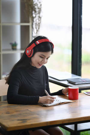 Over shoulder view of creative woman working with laptop computer.