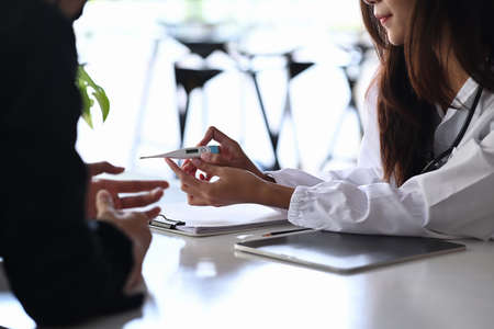 Female doctor holing patient hands and giving comfort her patient.の写真素材