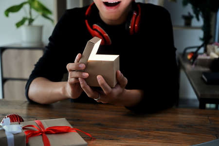 Excited young man opening Christmas gift box.の写真素材