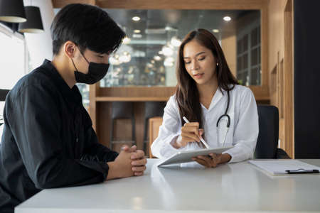 Young man patient having consultation with doctor in hospital.の写真素材
