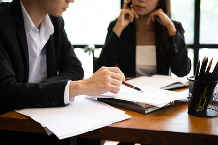 Businesswoman in wheelchair working on new business project with her colleague in office.の写真素材