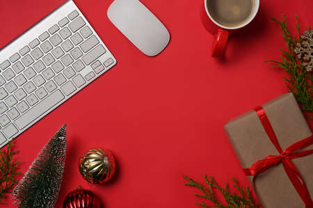 Gifts box, coffee cup, Christmas ornaments and fir tree branches on red background.の写真素材