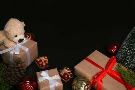 Christmas gift boxes and teddy bear decoration on dark background.