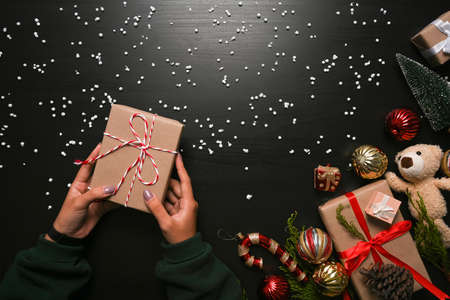 Female holding Christmas gift box on dark background.の写真素材