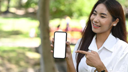 Asian woman wearing headphone and working with computer tablet in the park.の写真素材