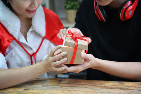 Happy asian couple holding opening Christmas gift box together.の写真素材