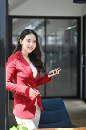 Portrait of confident businesswoman standing in office and smiling too camera.の写真素材