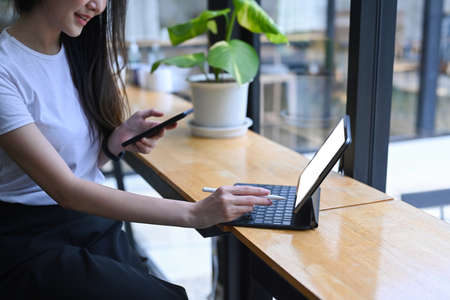 Charming young asian woman working online with computer tablet.の写真素材