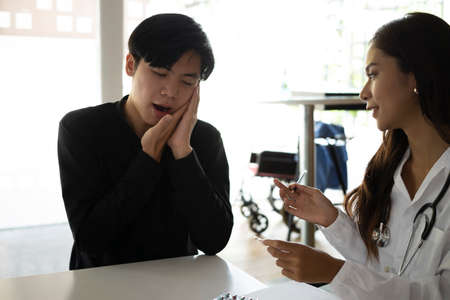 Doctor explaining treatment and giving advice to male patient.の写真素材