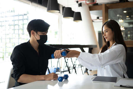 Young asian man doing treatment with physiotherapist in medical clinic.の写真素材
