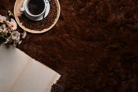 Empty notebook wooden tray with coffee cup and roasted coffee beans on brown carpet.の写真素材