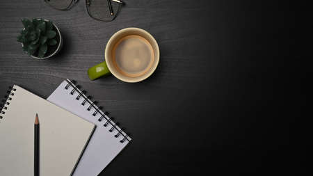 Above view empty notebooks, glasses and cup of coffee on black table.の写真素材