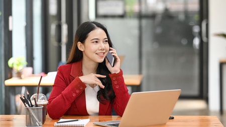 Successful businesswoman talking on smart phone with her business partner.の写真素材