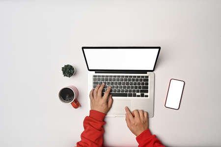 Overhead view man in red sweater using computer laptop on white background.の写真素材