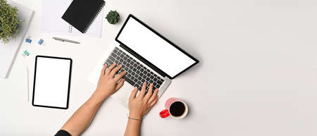 Young man in red sweater using computer laptop on white table.