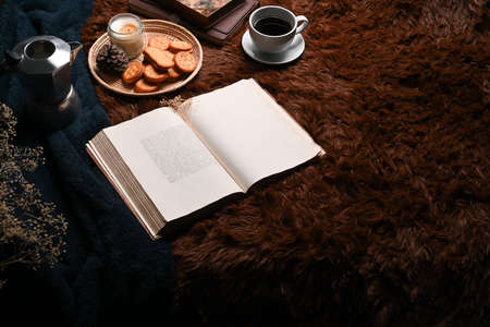 Coffee cup, book and tray of cookies on carpet.の写真素材