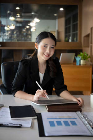 Charming asian businesswoman using digital tablet in modern office.の写真素材