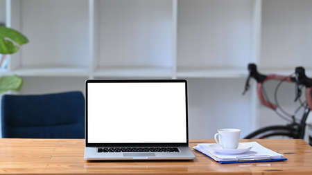 Mock up computer laptop, coffee cup and documents on wooden table.の写真素材