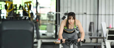 Fitness woman in sportswear  workout cycling bikes in the gym.の写真素材