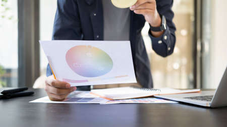 Cropped shot creative designer writing information on documents.の写真素材