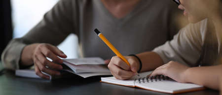 Female private tutor helping young student doing homework . Tutorial and educational concept.の写真素材
