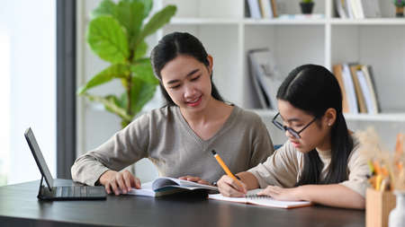 Young mother helping her daughter with homework at home.の素材 [FY310177270039]