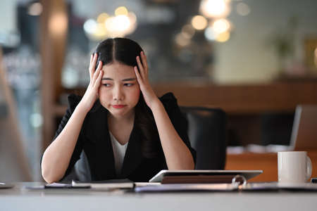 Frustrated businesswoman sitting in front of computer in office.の写真素材