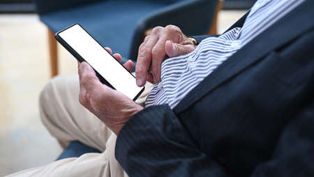 Cropped shot businessman sitting in office and using smart phone.