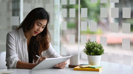 Confident businesswoman holding coffee cup and talking on mobile phone.