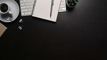 Top view notebook, wireless keyboard and coffee cup on black background.の写真素材