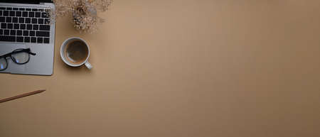 Top view empty notebook, coffee cup and stationery no beige background.の写真素材