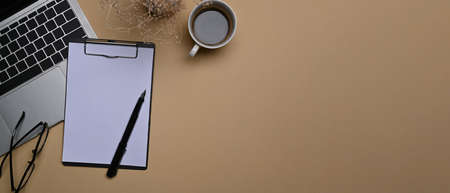 Top view empty notebook, coffee cup and stationery no beige background.