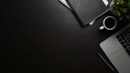 Flat lay modern workspace with computer laptop, coffee cup and book on black table.の写真素材