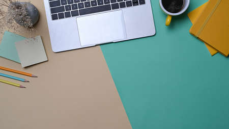 Computer laptop, coffee cup, sticky notes and stationery on colorful background.の写真素材