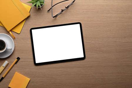 Top view mock up digial tablet, coffee cup and stationery on wooden table.の写真素材