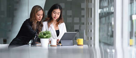 Two young asian businesswoman working together in modern office.の写真素材
