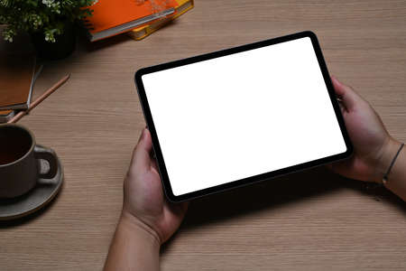 Overhead view female holding mock up digital tablet with white screen on pink background.の写真素材