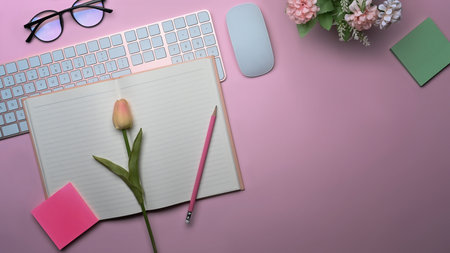 Overhead view woman workspace with laptop computer, notebook, coffee cup and pink tulips.の写真素材