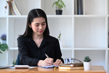 Charming businesswoman working in modern workplace.の写真素材
