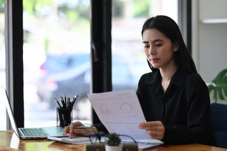 Charming businesswoman working in modern workplace.の写真素材