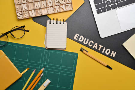 Above view laptop computer, glasses and stationery on yellow background. Back to school concept.の写真素材