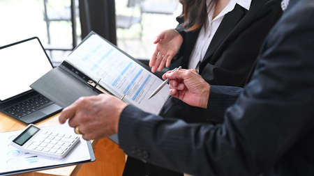 Smiling female agent offering health insurance for elderly man in office.の写真素材