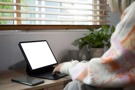 Cropped shot female browsing internet with computer tablet at home.