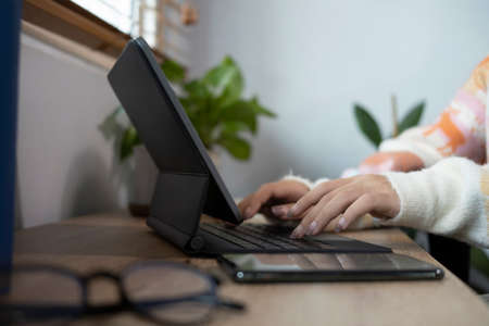 Young asian woman sitting on comfortable chair and using computer.