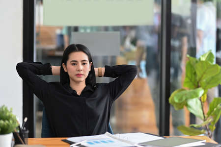 Asian businesswoman relaxing at comfortable office chair.