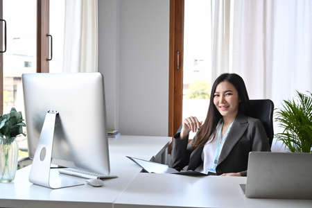 Confident businesswoman working with laptop computer in office.の写真素材