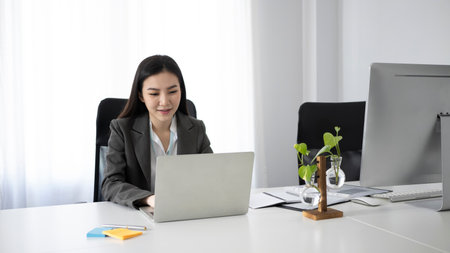 Side view beautiful businesswoman working with computer in modern workplace.の写真素材