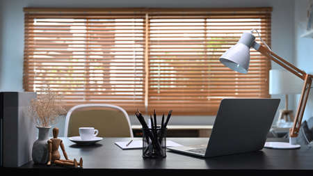 Comfortable workplace with laptop computer and supplies in home office interior.の写真素材